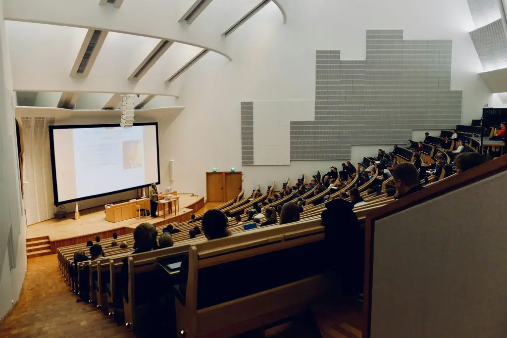 A raked university lecture theatre with rows of desks.